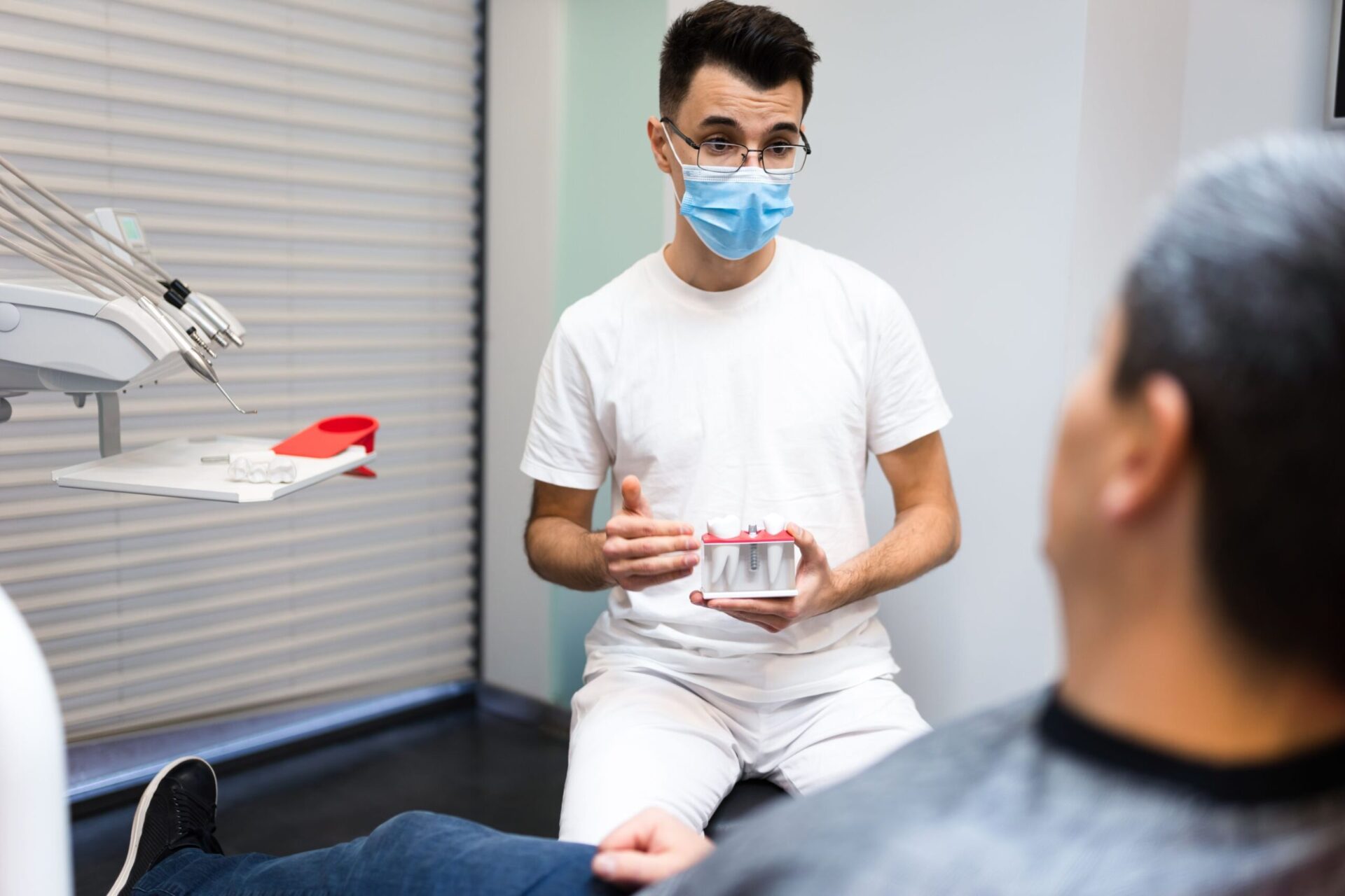 Tandarts laat tandimplantaten zien aan patient